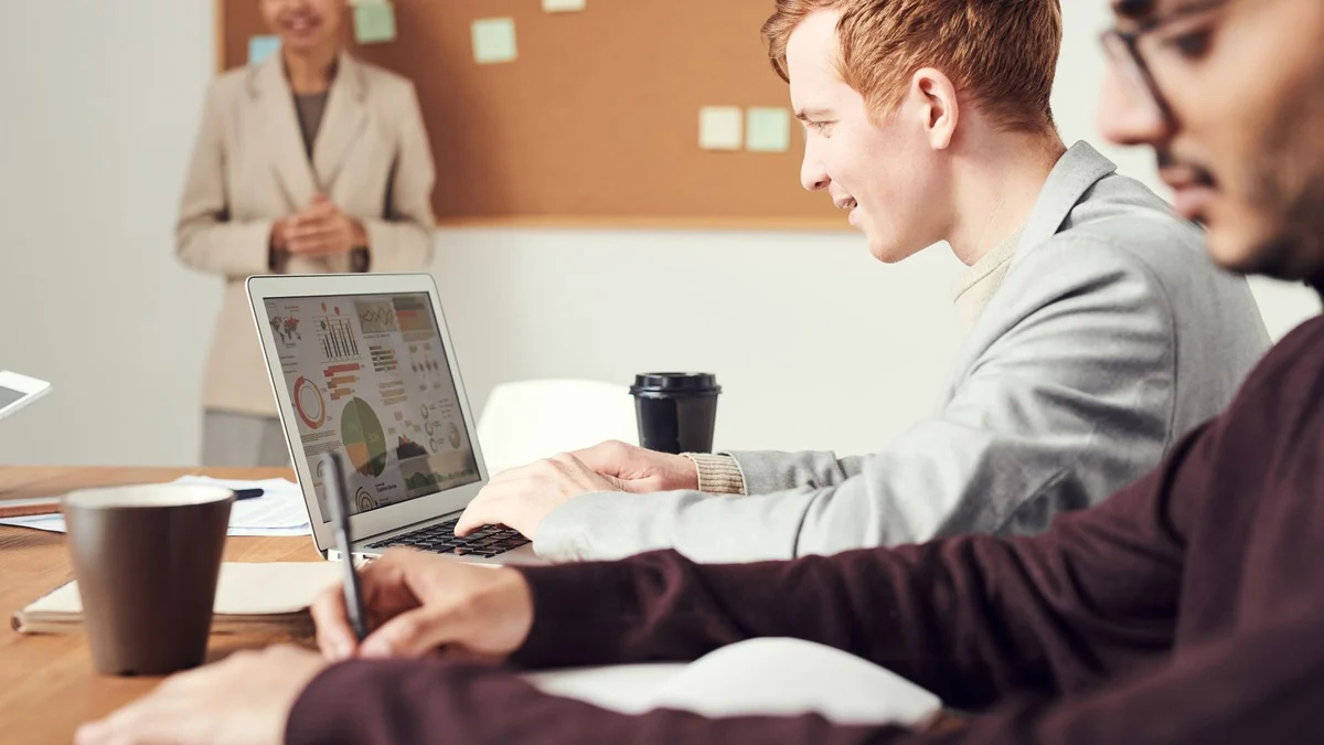 Equipo profesional reunido alrededor de una laptop para trabajar comunicación laboral