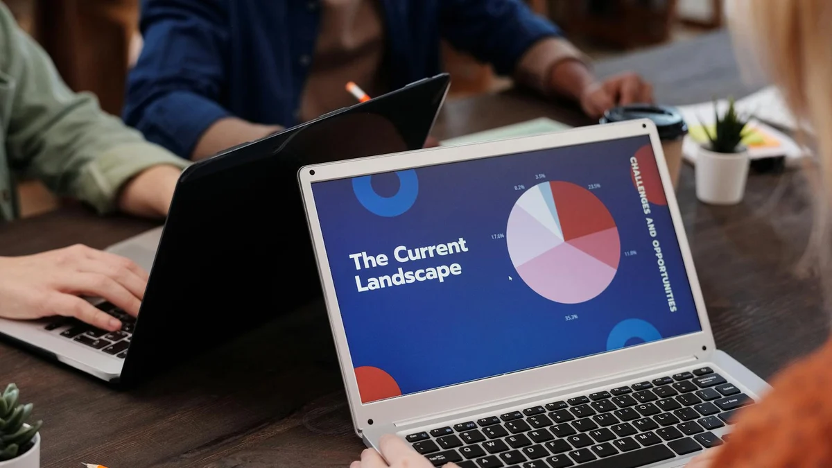 Reunión profesional con laptop y gráficos para contexto de inglés de negocios